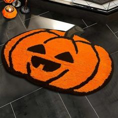 an orange rug with a smiling pumpkin on it