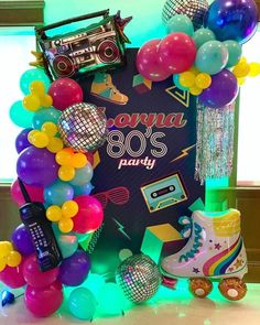 a party decoration with balloons, disco balls and an old school record player on it