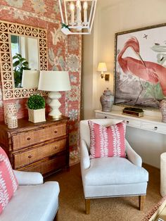 a living room with two chairs and a painting on the wall behind them in front of a mirror