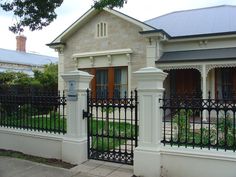 a white house with a black iron fence