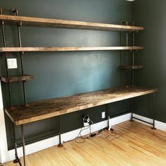 an empty room with some shelves on the wall and wires in front of it,