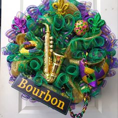 a door wreath with a saxophone on it and the name bourbon written in gold letters