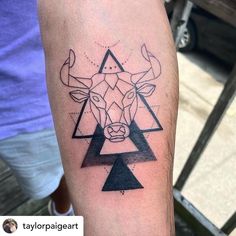 a tattoo on the arm of a man with an animal head and triangles in it