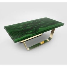 a green table sitting on top of a white floor next to a metal stand with gold legs