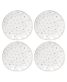 four white plates with blue speckles on them