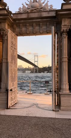 an open door leading to the water with a bridge in the background