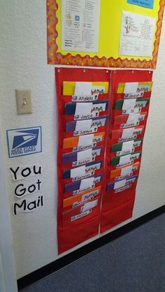 an office cubicle with mail boxes on the wall and bulletin board attached to it