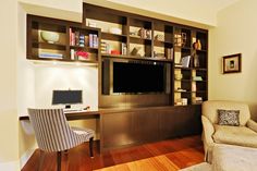 a living room filled with furniture and a flat screen tv on top of a wooden shelf