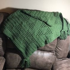 a green blanket sitting on top of a couch