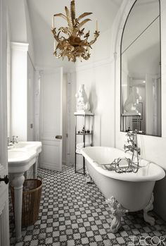 an image of a white bathroom with black and white floor tiles on the walls, chandelier above the bathtub