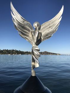 a statue of an angel sitting on top of a boat