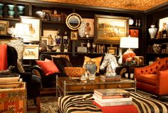 a living room filled with lots of furniture and pictures on the wall above it's fireplace