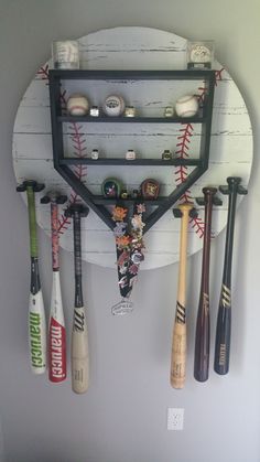 a baseball bat and some baseballs hanging on a wall with other items attached to it