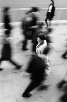 a black and white photo of people walking down the street