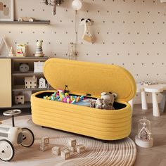 a yellow toy box filled with toys on top of a wooden floor next to a wall