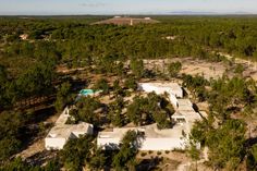 an aerial view of a house surrounded by trees in the middle of a wooded area