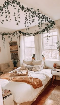 an unmade bed in a bedroom with lots of greenery on the ceiling and windows