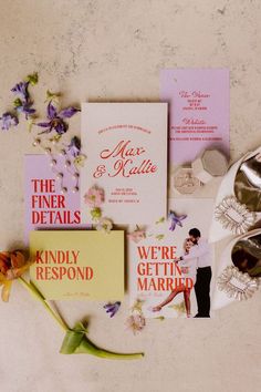 the wedding stationery is laid out on top of the table with flowers and other items