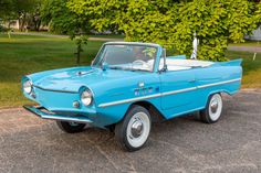 an old blue car is parked on the street