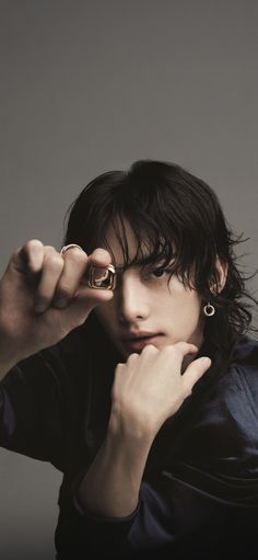 a man with long hair and piercings on his fingers