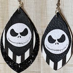 the jack skellingy earrings are decorated with black and white glitters on them