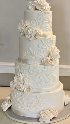 a three tiered white wedding cake with flowers