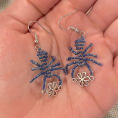 a pair of blue beaded earrings in the palm of someone's hand