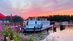 there is a boat that is docked on the water with flowers in front of it