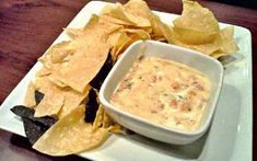 a white plate topped with chips and dip