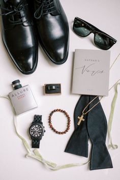 an assortment of men's clothing and accessories laid out on a white table top