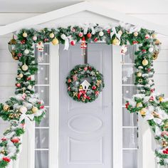 a white door decorated with christmas decorations and wreaths