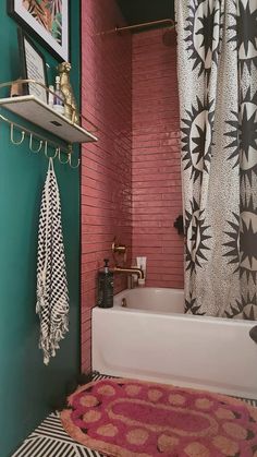 a bath tub sitting under a window next to a shower curtain in a room with red brick walls