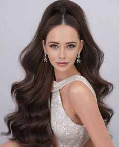 a woman with long brown hair wearing a white dress and diamond earrings on her head