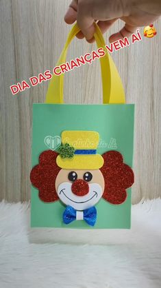 a hand holding a green bag with a clown face on it