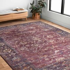 a large area rug in a room with wooden flooring and window sill on the far wall