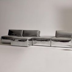 a silver couch sitting on top of a white floor