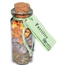 a glass jar filled with lots of different types of rocks and gravel next to a tag that says ferility