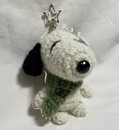 a crocheted dog keychain with a green scarf around it's neck