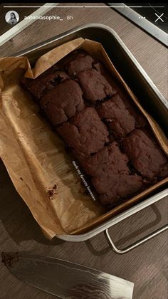 a pan filled with brownies sitting on top of a table next to a knife