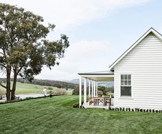 a white house sitting on top of a lush green field