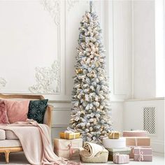 a white christmas tree with presents around it