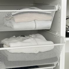 two white bins with folded towels in them