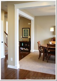 an empty dining room and living room with wood flooring in the middle of it