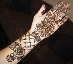 a woman's hand with henna tattoos on it