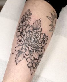 a black and white flower tattoo on the arm