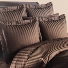 black and white photograph of bedding with stripes on the comforter, pillows and pillowcases