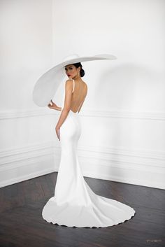 a woman in a white dress with a large hat on her head