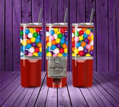 two sodas with gumballs in them on a wooden floor next to purple walls