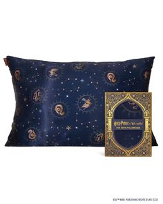 a decorative pillow with a book on it and an image of the moon in the sky