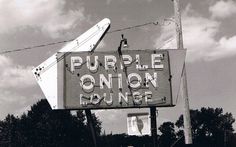 a black and white photo of a purple onion lounge sign